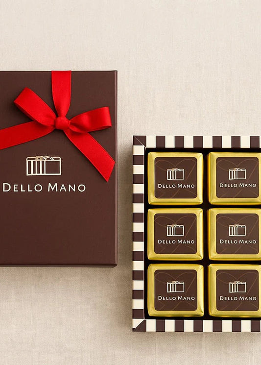 Dello Mano chocolate brownies with a brown gift box and red ribbon on a beige background