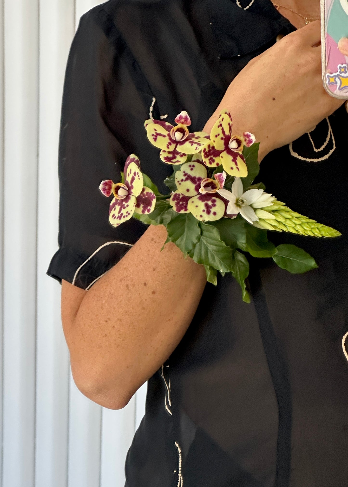 Burgundy and yellow orchids with greenery corsage.